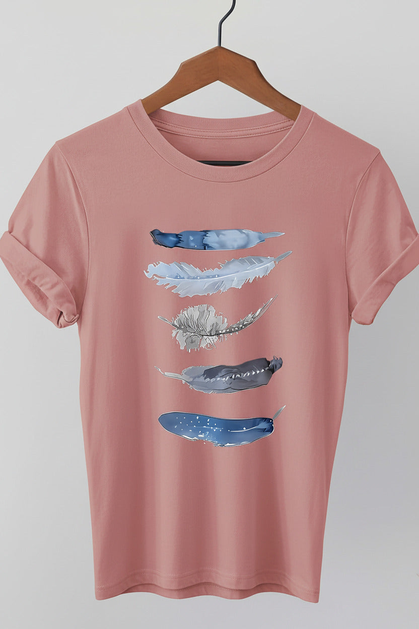 Pink t-shirt with abstract blue designs on a hanger against a denim background